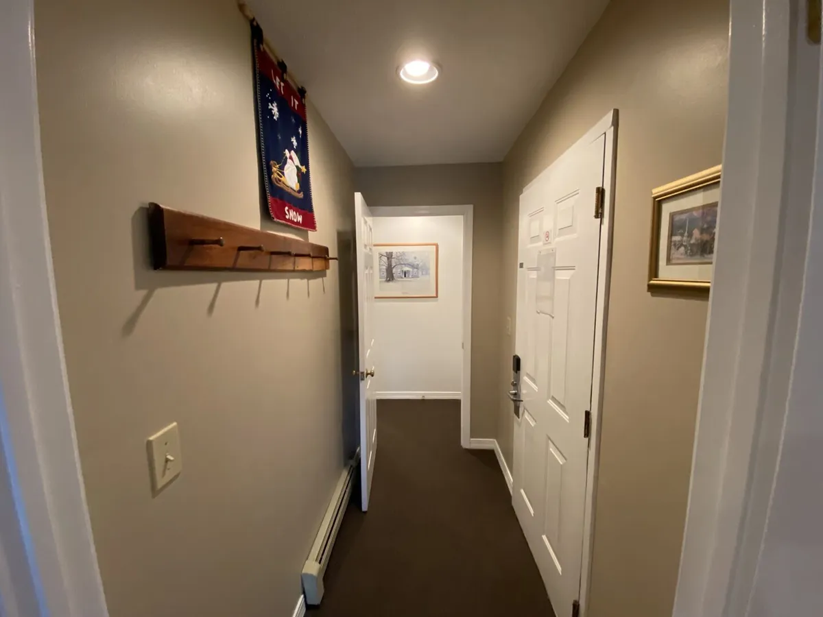 This image captures the property’s entryway, featuring a wall-mounted coat rack, decorative wall hanging, and framed artwork. The view suggests a welcoming transition space where guests can hang up their gear after outdoor adventures.